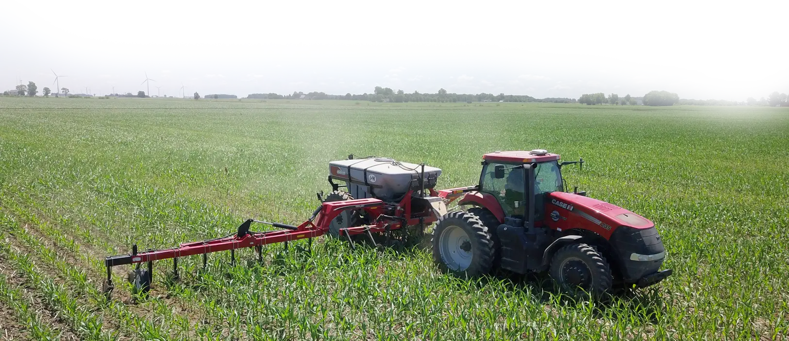 Red 6018 NitroGro Nitrogen Applicator Applying Liquid Nitrogen to a Field of Corn