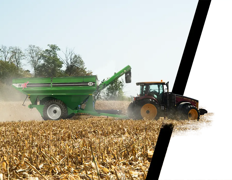 a green 1112 walking tandem grain cart sitting next to a corn field