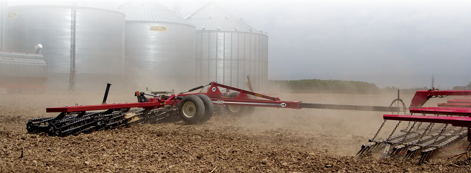 a green soil conditioner being pulled through a field.