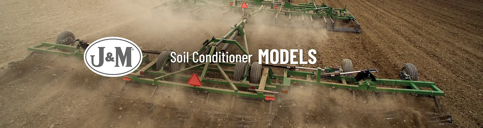 soil conditioner that is green being pulled through a field with a j and m logo