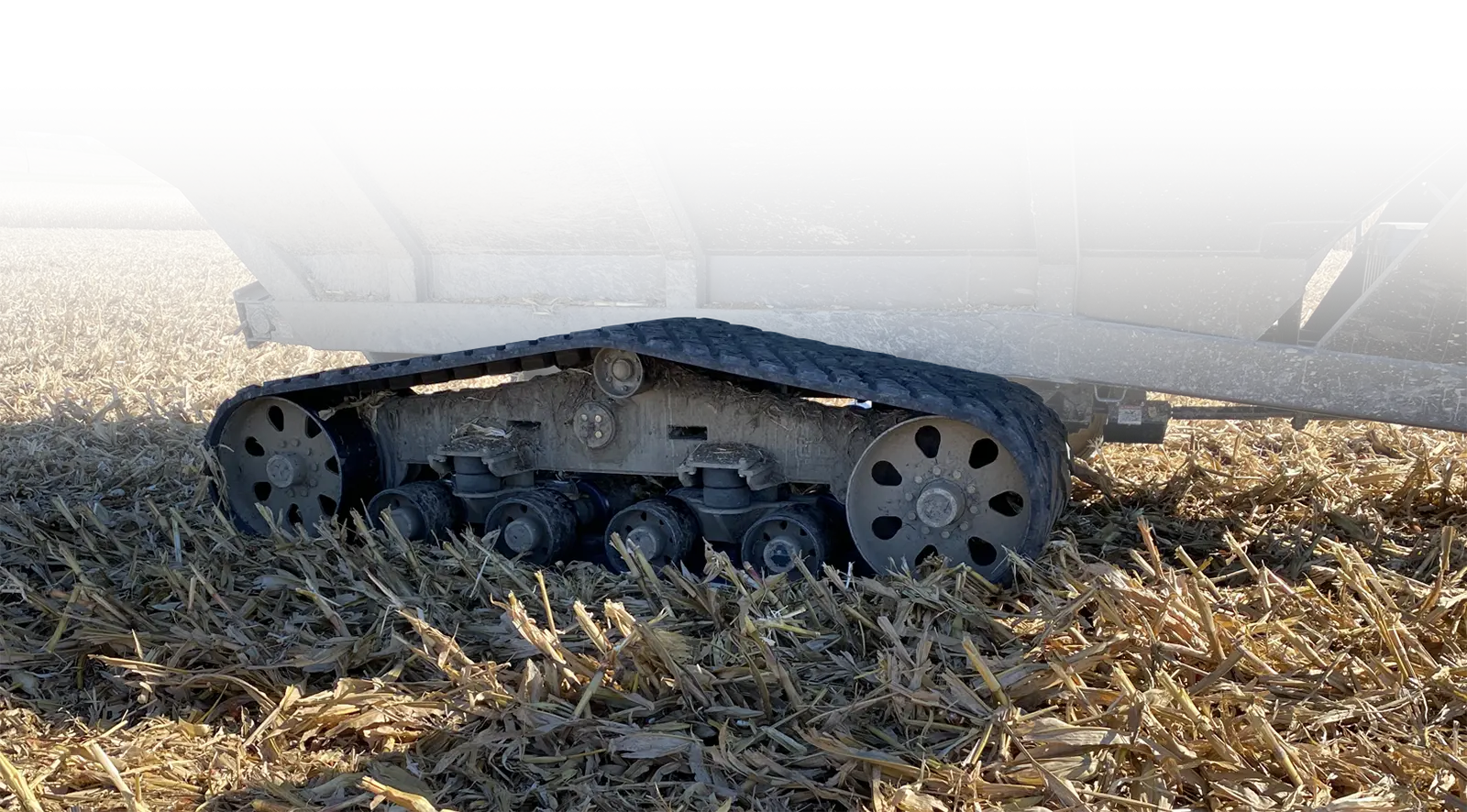 a photo highlighting the tracks on a grain cart in a field.